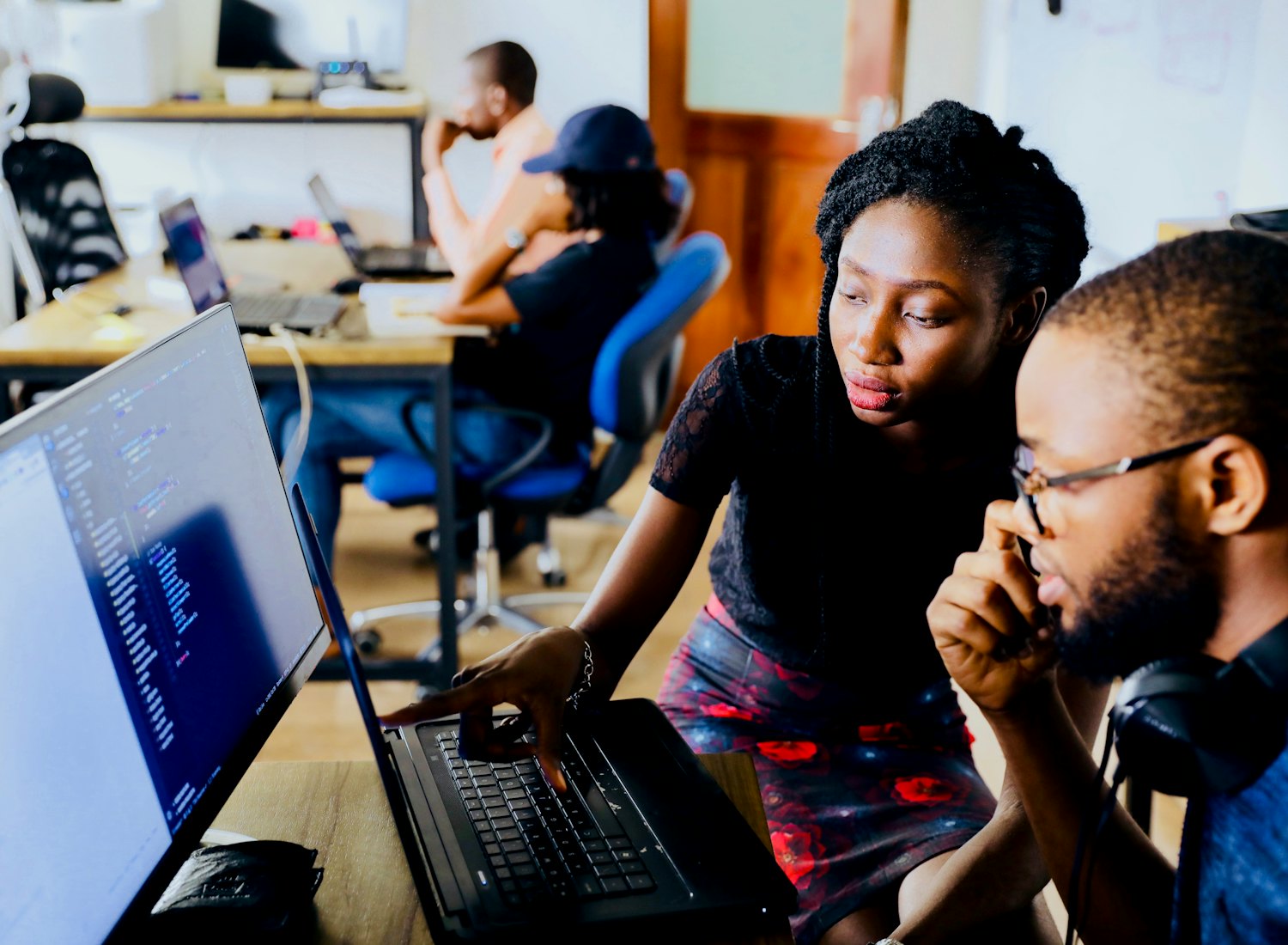 Deux apprenants en binôme devant un écran de code